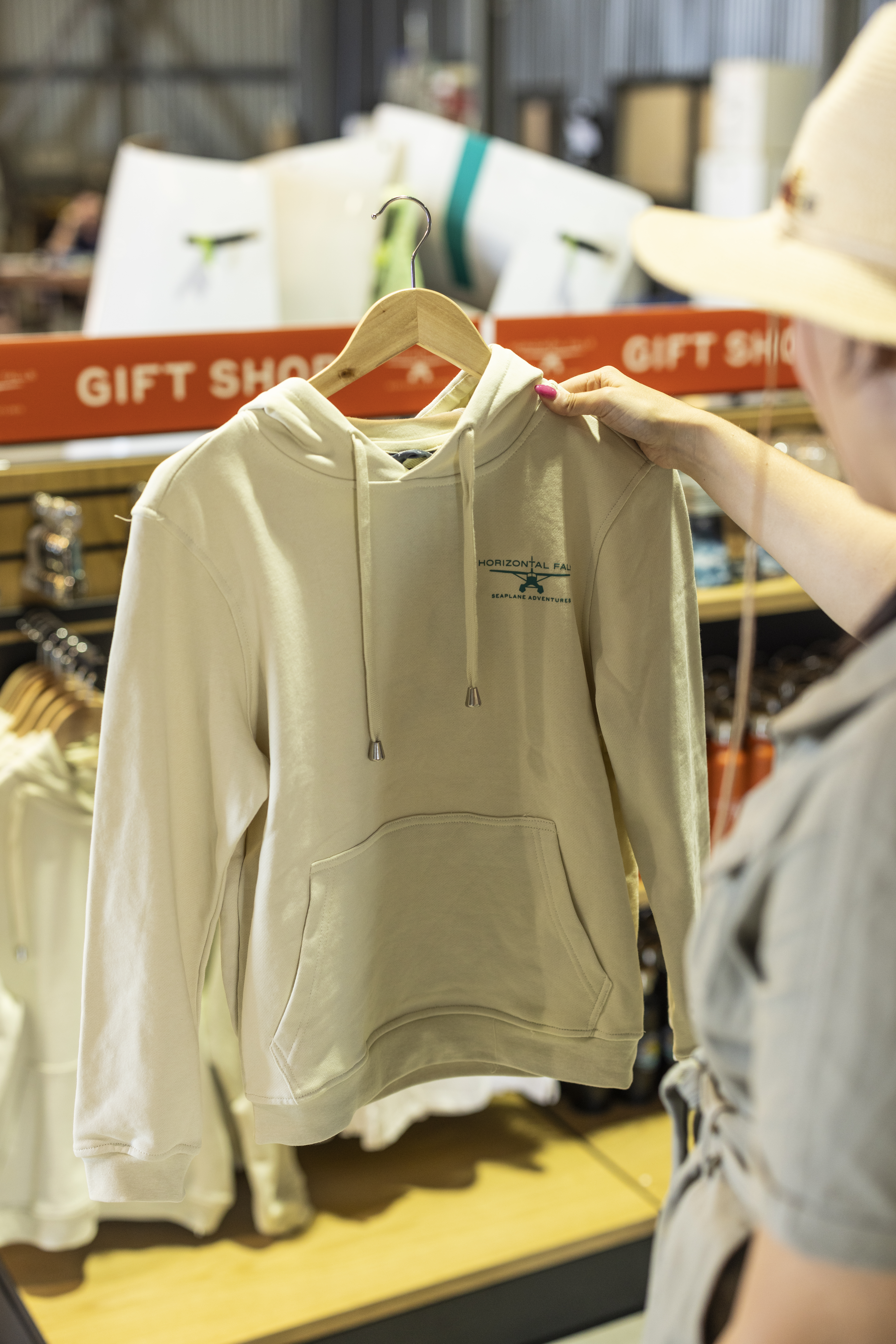 A person holds up a lightweight hoodie available for purchase at the gift shop.
